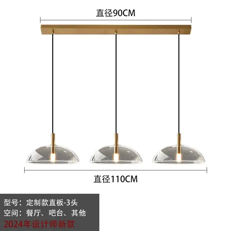 Modern gold pendant light with brass bar and clear dome glass pendant shades featuring intricate mesh pattern for kitchen