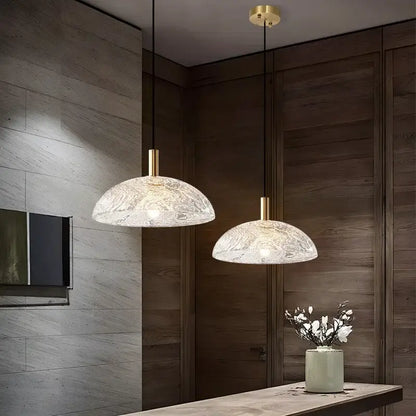 Two elegant gold-toned glass pendant lights with textured frosted finish for modern kitchen and dining room use