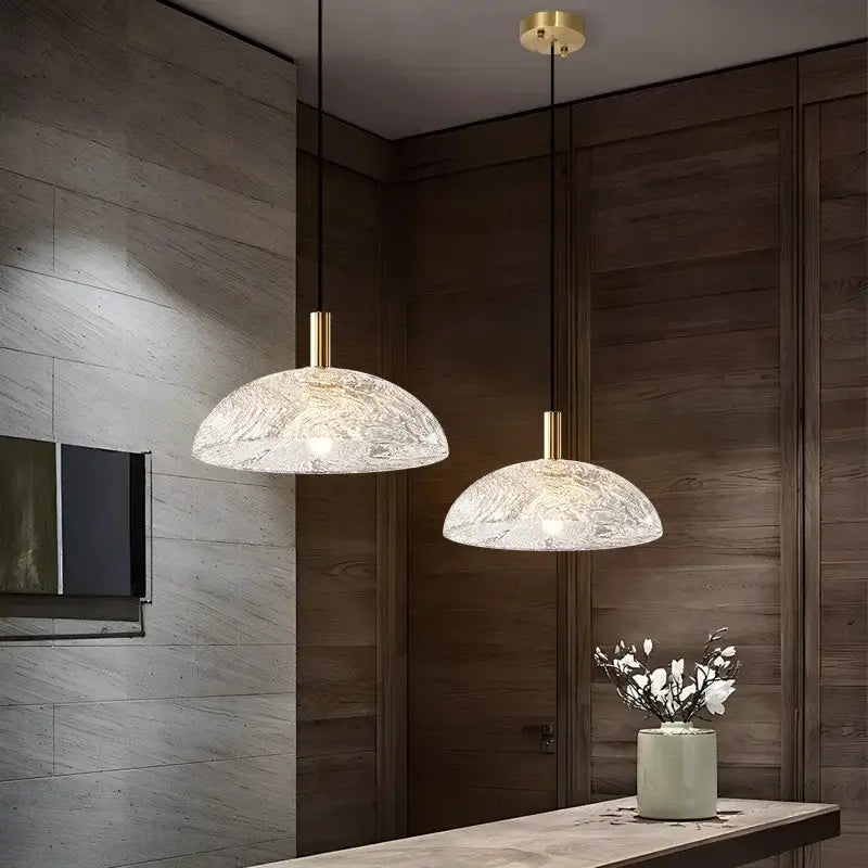 Two elegant gold-toned glass pendant lights with textured frosted finish for modern kitchen and dining room use