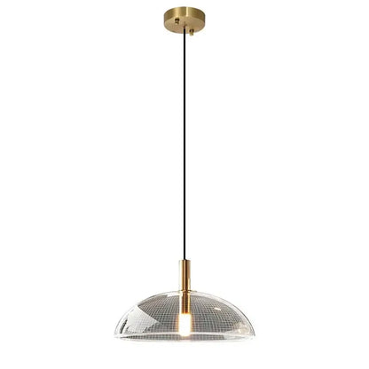 Modern gold pendant light with a brass ceiling mount and textured clear glass pendant featuring a grid pattern