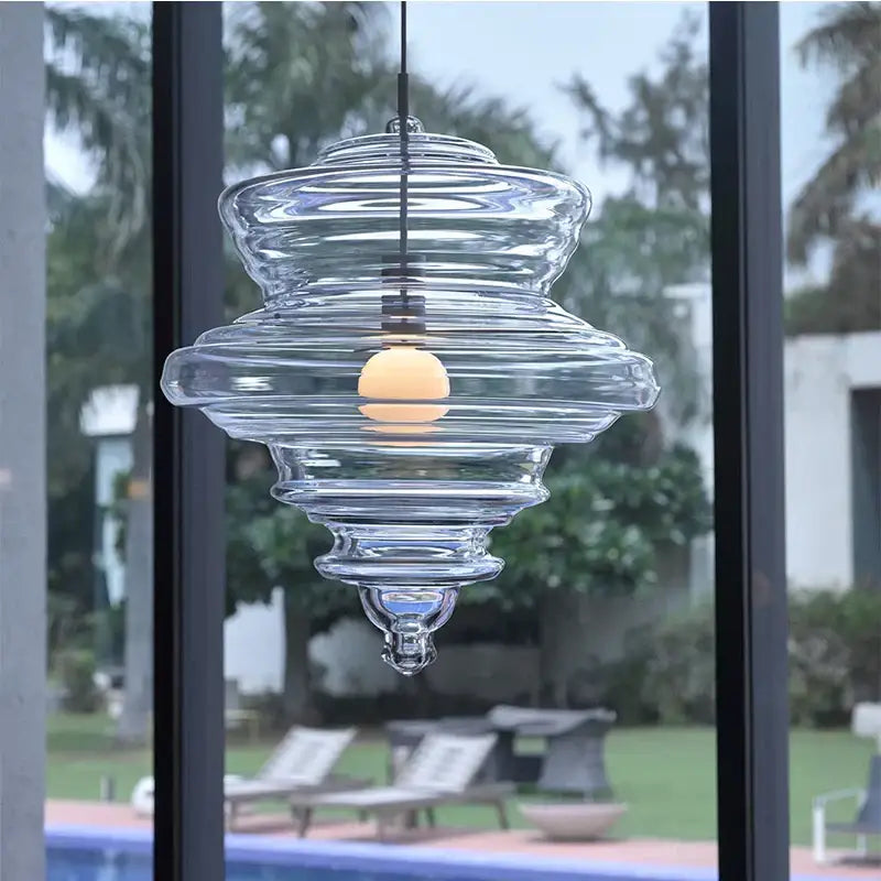 Modern gold and white decorbites glass chandelier featuring a clear glass pendant light with tiered ribbed design and warm bulb