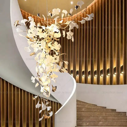 Elegant modern gold and white gingko leaf ceramic chandelier hanging above a staircase by decorbites gingko leaf design