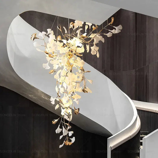 Elegant modern gold and white gingko leaf ceramic chandelier by decorbites hanging above a staircase