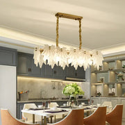 Modern gold pendant light fixture with white glass floral shades and twisted chain frame for dining room use
