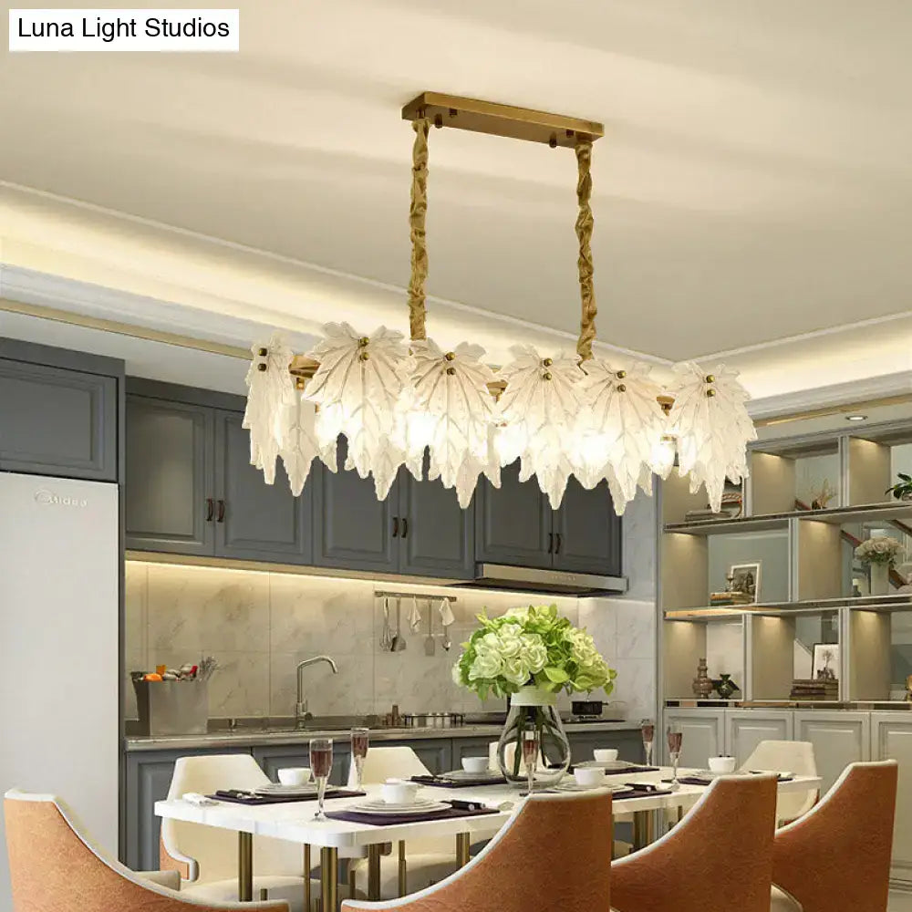 Modern gold and white glass floral pendant light featuring a white glass leaf-shaped chandelier with gold metal frame and rope chains