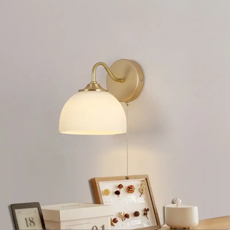 Modern gold and white glass wall lamp with brass finish and softly glowing ribbed white glass shade by decorbites iron white