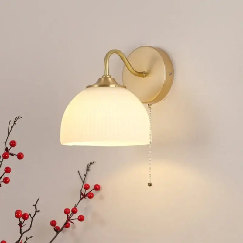 Modern gold and white glass wall lamp with warm-toned brass arm and ribbed white glass shade by decorbites iron white