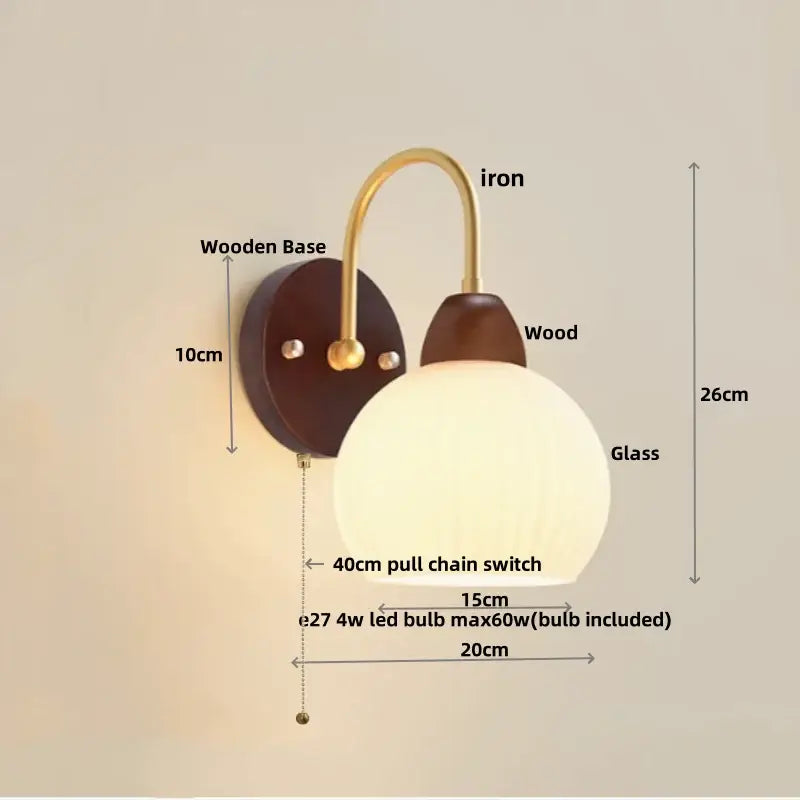 Modern gold and white glass wall lamp with warm-toned glass globe, brass iron arm, and dark wood base decorbites iron white