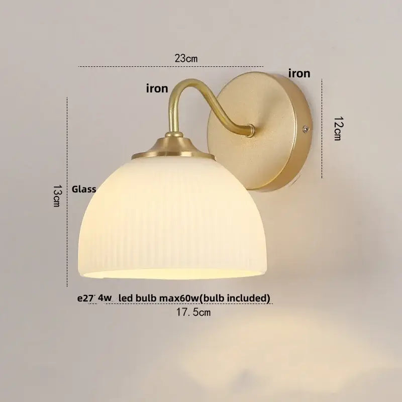 A warm-toned modern gold and white glass wall lamp with a brass-finished iron frame and ribbed white glass shade by decorbites iron white
