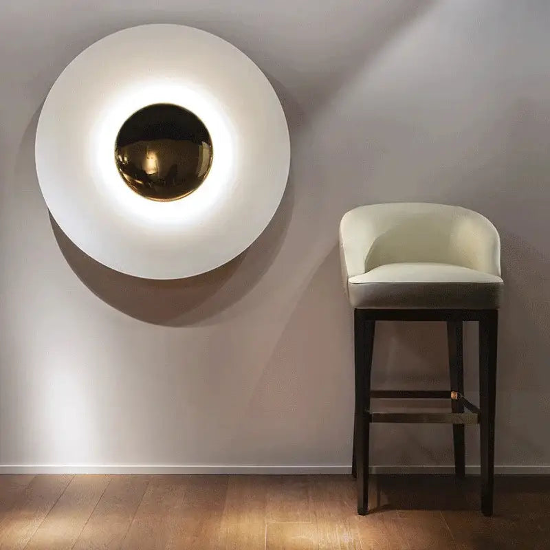 A modern gold and white led ufo wall sconce with a polished gold center for bedroom ambiance wall sconces