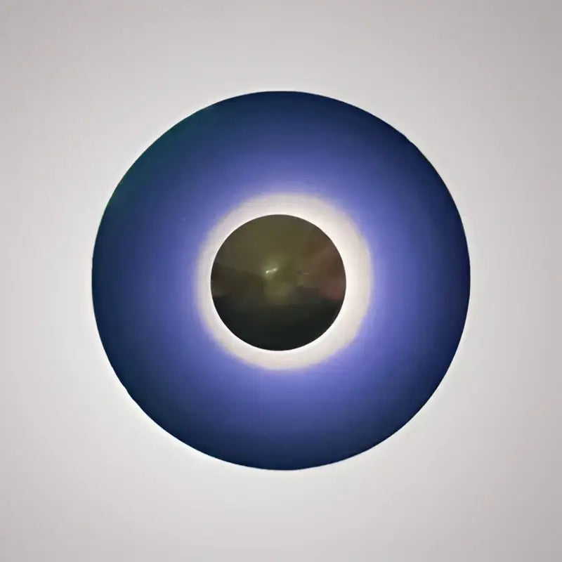 Modern gold and white led ufo wall sconces featuring a circular blue eclipse design with dark disk and bright corona