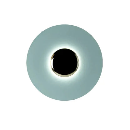 A sleek circular led ufo wall sconce with matte teal diffuser and polished chrome ring for modern bedroom ambiance