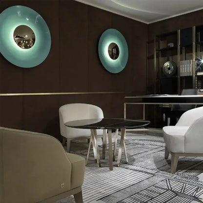 Two teal glossy circular led ufo wall sconces with reflective centers for modern bedroom ambiance lighting