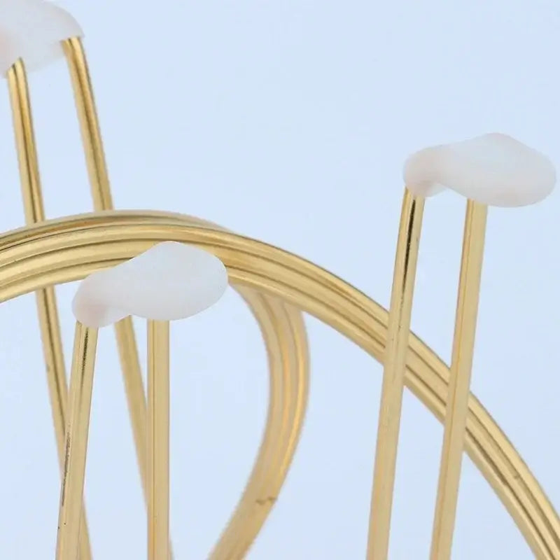 Modern gold metal mug holder stand with white rounded plastic caps for kitchen use on marble tray base