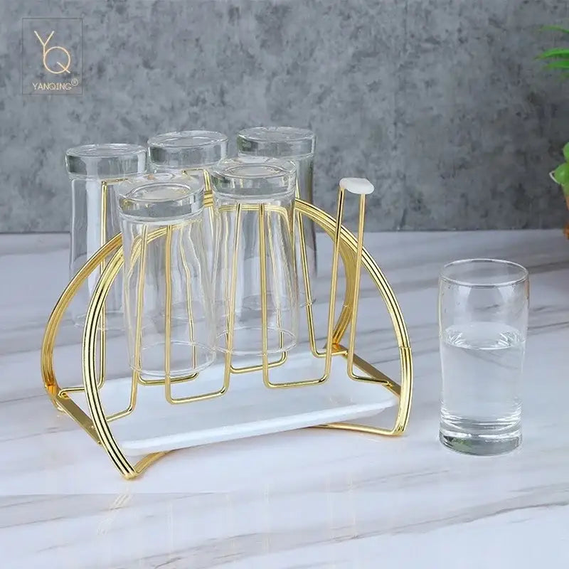 Modern gold and white marble mug holder stand with six clear drinking glasses for kitchen organization