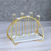 Modern gold and white marble mug holder stand with a rounded curved gold-toned metal cup holder and marble base