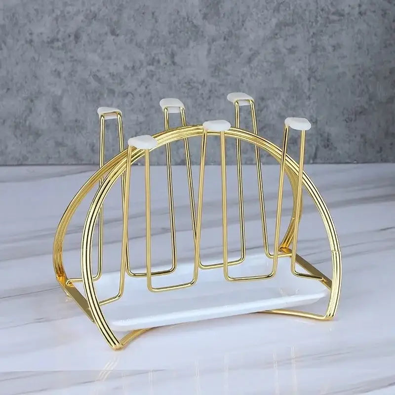 Modern gold and white marble mug holder stand with a rounded curved gold-toned metal cup holder and marble base