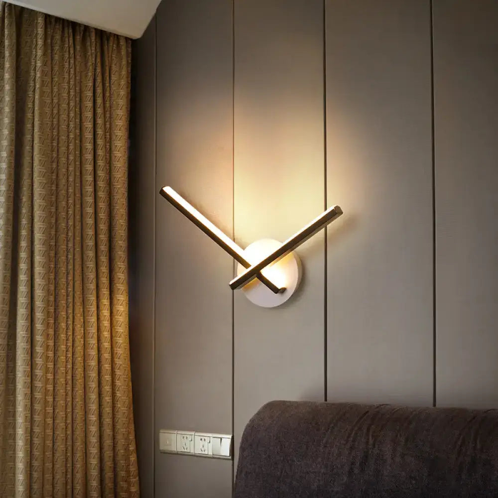Modern gold angular wall lamp with warm white light featuring black white circular base and intersecting metal arms