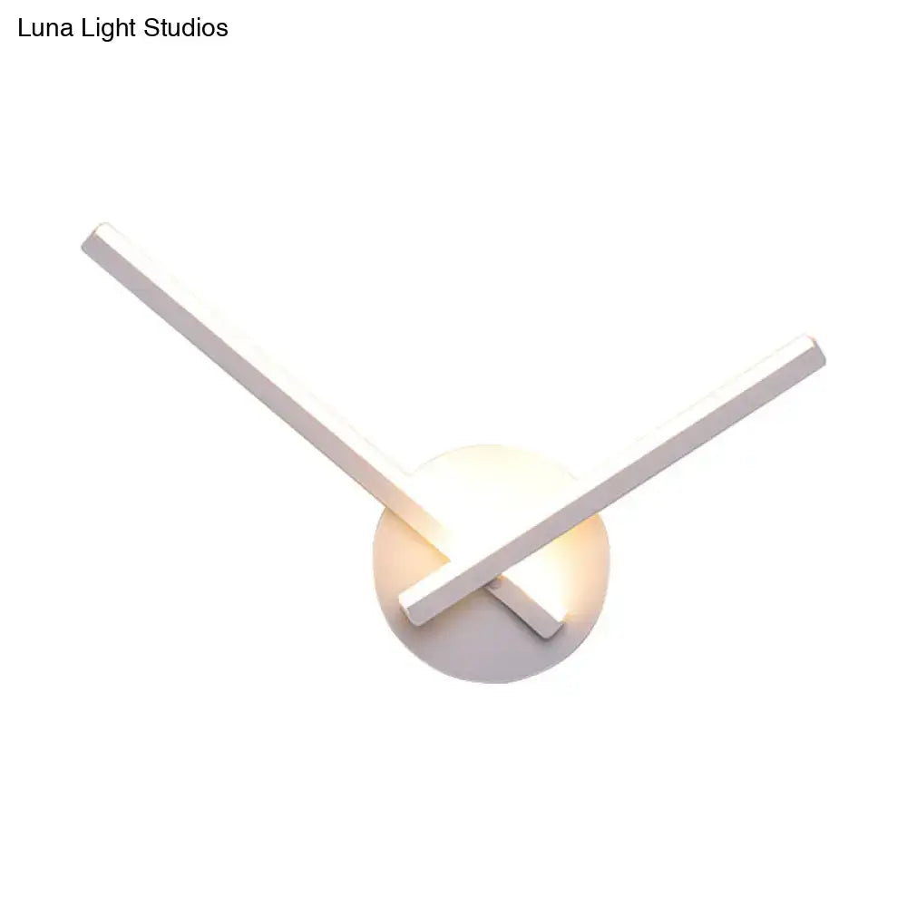 Minimalist gold wall lamp with intersecting rectangular arms and warm white light for modern bedroom decor