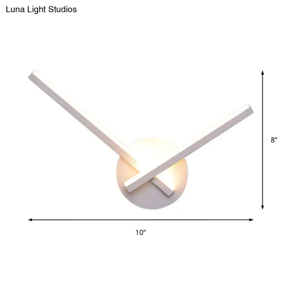 Modern white wall lamp with two intersecting rectangular arms and warm white light for bedroom lighting