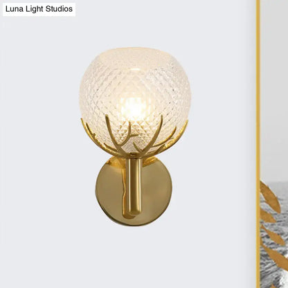 Modern 1-light gold wall sconce with antler design metal arms and textured frosted globe with clear latticed glass