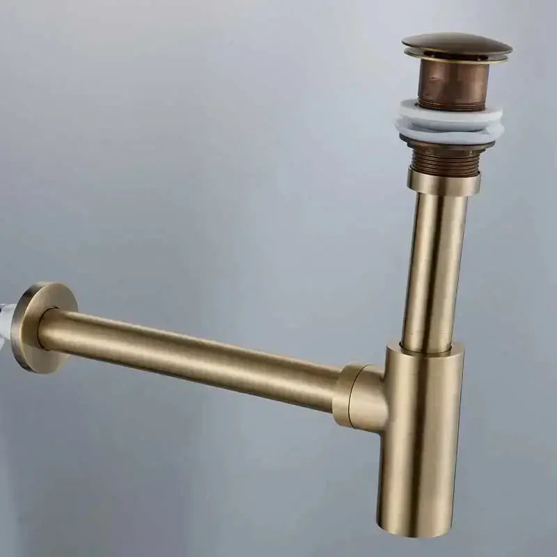 Modern gold basin tap siphon kit featuring a brass-colored drain pipe with cylindrical stopper and white rubber seal