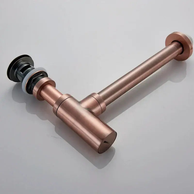 Modern gold basin tap siphon kit featuring a copper-finished bathroom sink drain with a black rubber stopper and sleek design