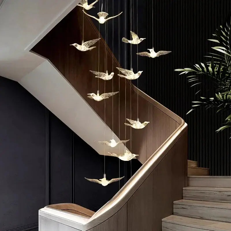 Modern gold bird design led chandelier with elegant translucent glass bird design led pendants above staircase decorbites bird design