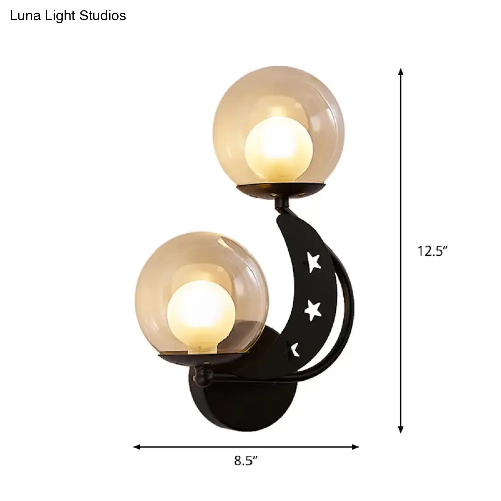 Black crescent moon wall sconce with gold accents and frosted glass ball shades for modern bedroom lighting