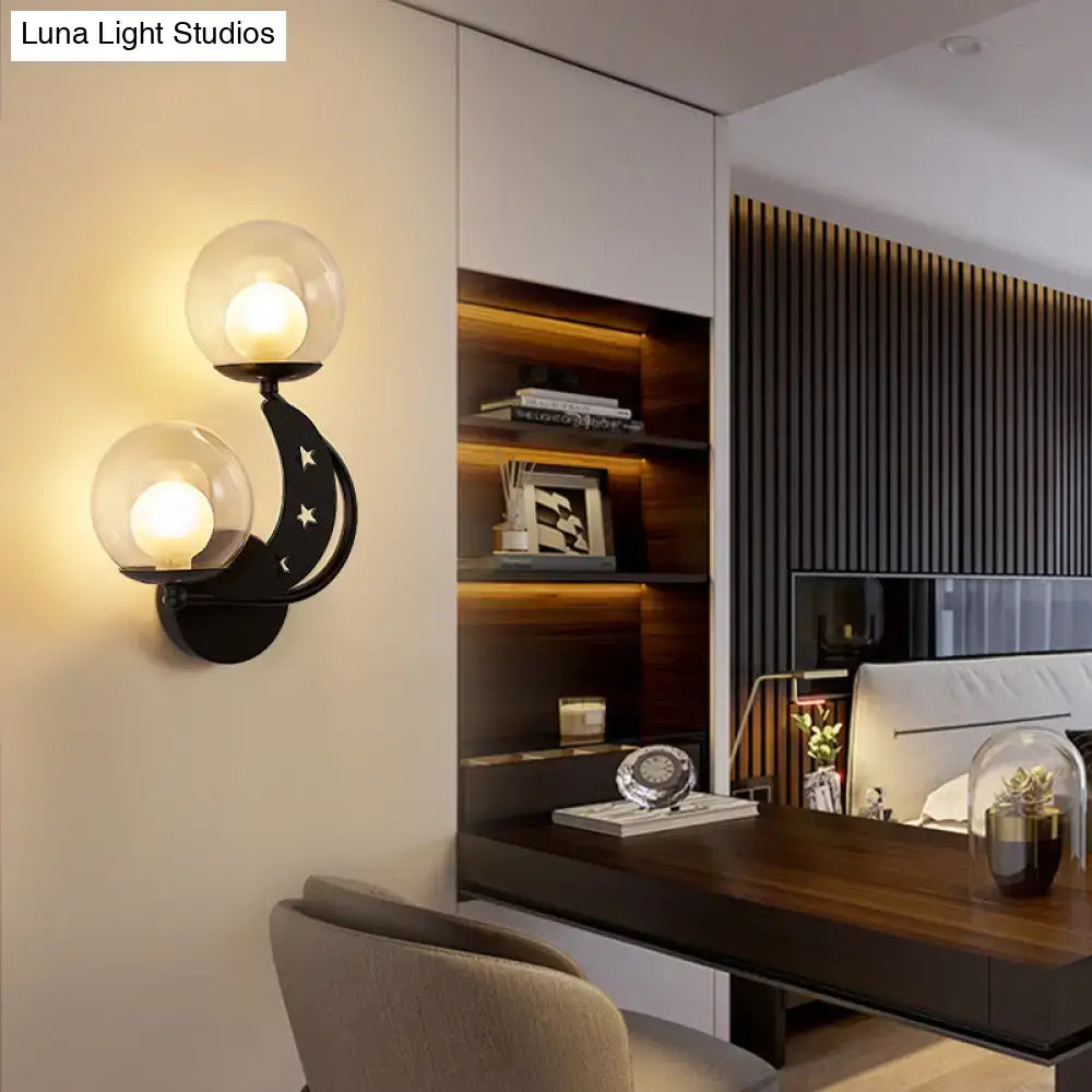 Modern gold and black ball wall sconce with two spherical glass shades and crescent moon design for bedroom lighting