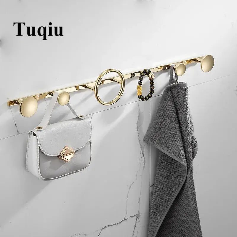 Modern gold and black brass towel hook set featuring gold-toned tuqiu wall-mounted hooks with sleek circular design