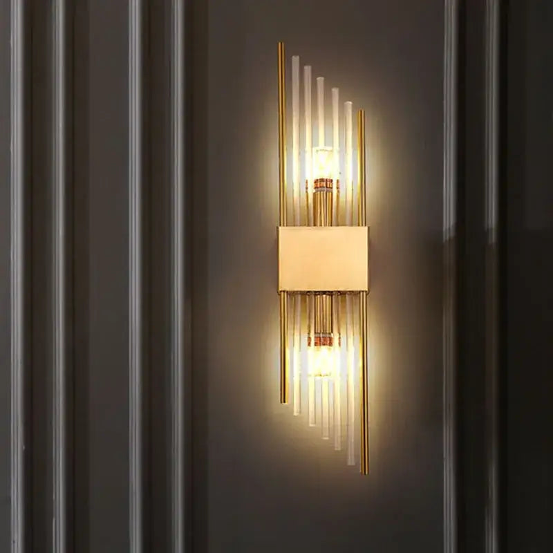 Modern gold and black crystal wall lamp featuring a gold-toned sconce with vertical glass rods and central rectangular shade