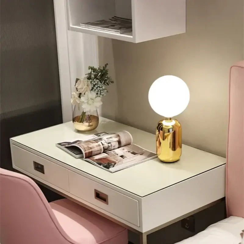 A sleek spherical gold decorbites glass ball led desk lamp with glossy finish and minimalist design for bedroom use