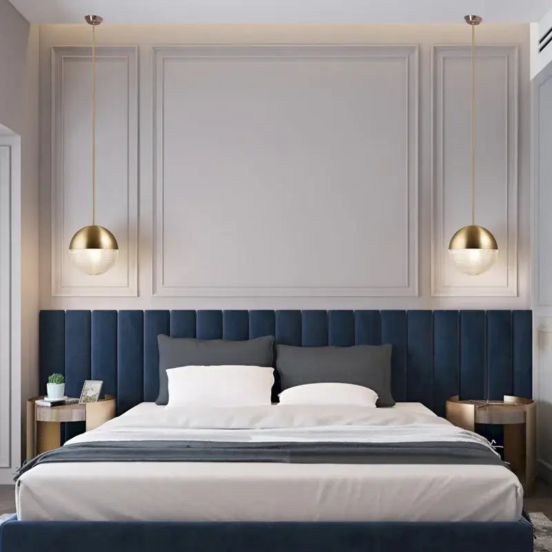 Deep blue tufted velvet headboard with matching bed skirt and panels under modern gold and black decorbites glass ball led pendant light