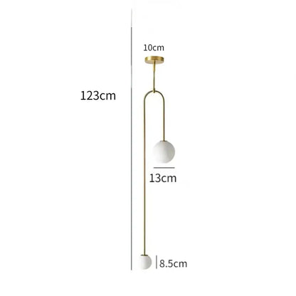 A modern gold and black glass globe pendant light with slender metal detailing and two white glass shades for dining room