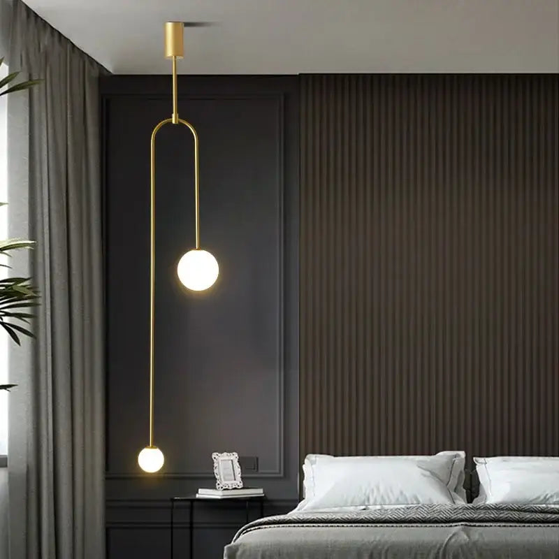 Modern gold and black pendant light with glass globe bulbs and metal detailing for dining room lighting