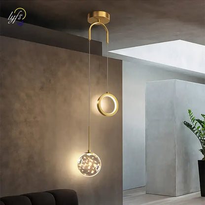 Modern gold pendant light with black glass globe and warm led lights featuring selectable light colors for dining rooms