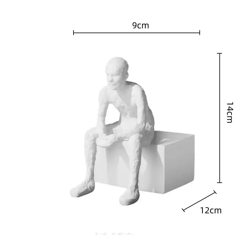 White resin sculpture of a seated figure with textured design paired with decorbites golden arches metal bookend