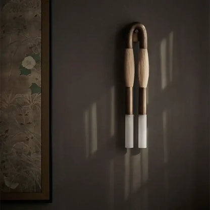 Modern gold and black decorbites horsehair wall lamp with light-toned wood arms and frosted glass shades wall lamp