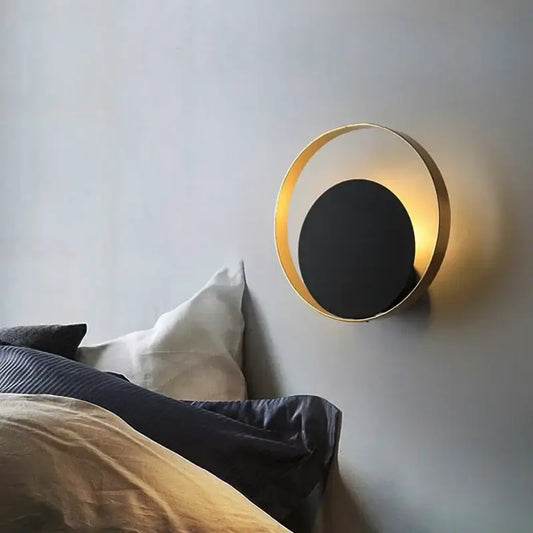 A sleek modern wall sconce with gold-toned circular frame and matte black disc for elegant led wall decorbites lighting