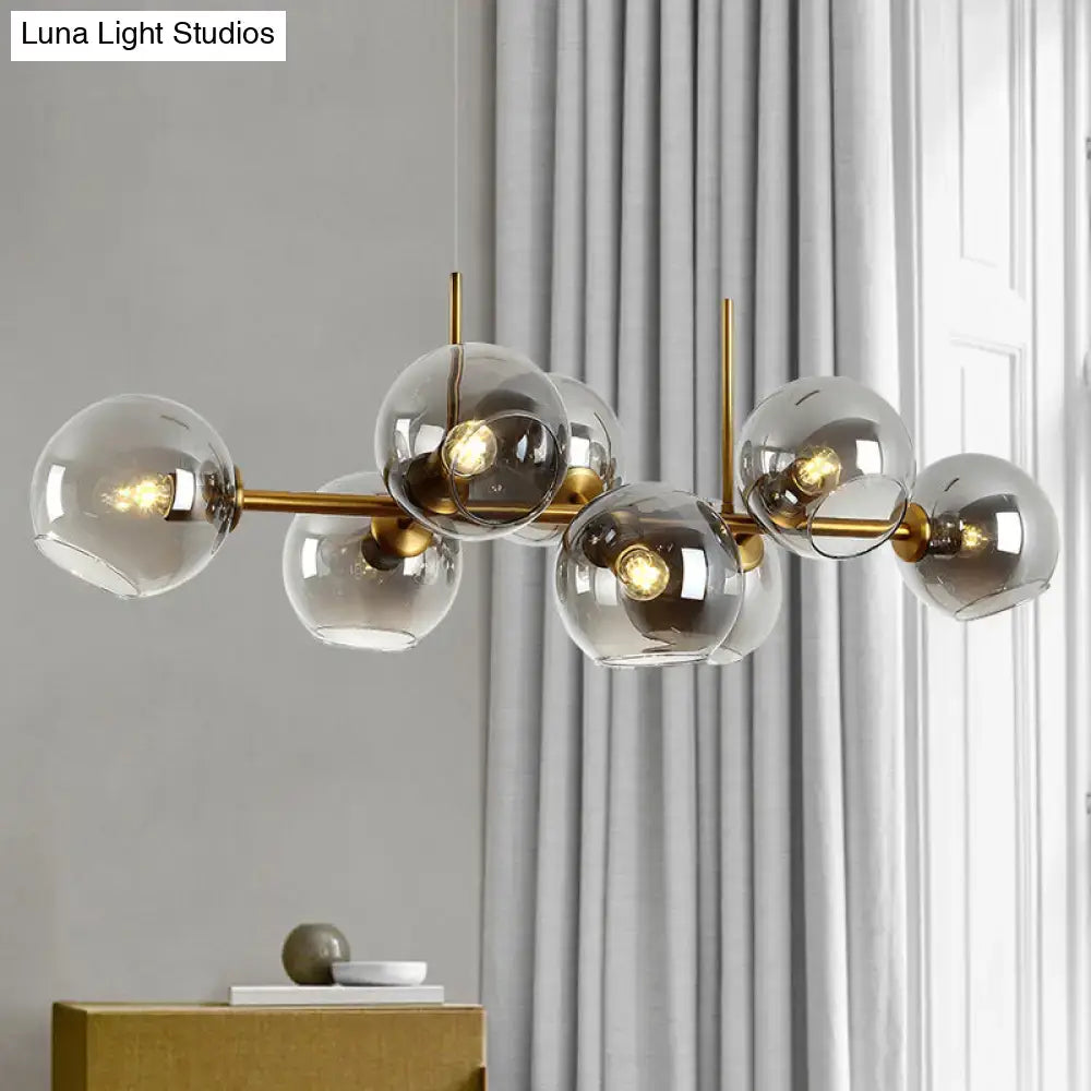 Modern gold and black linear design kitchen island light with brass finish and multiple smoky glass globe shades fixture width