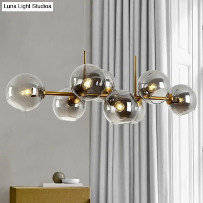 Modern gold and black linear design kitchen island light with brass finish and multiple smoky glass globe shades fixture width