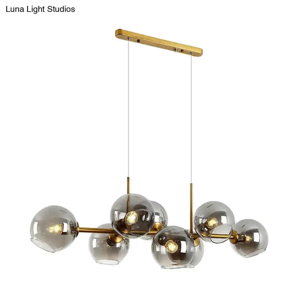 Modern gold and black linear design kitchen island light fixture with smoky glass and brass spherical bulbs in pendant style