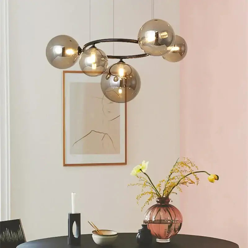 Modern gold and black magic bean ceiling chandelier featuring a spherical glass pendant light with a black metal frame