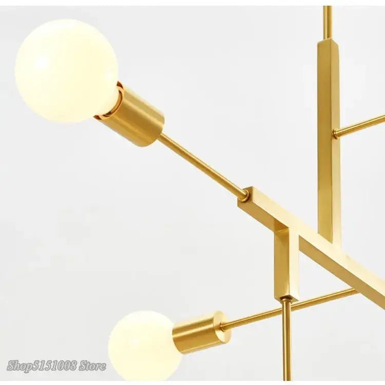 Modern gold and black pendant light with spherical frosted glass bulbs and decorbites cross style metal arms for dining room