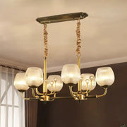 Modern gold and black ribbed glass island chandelier with six textured glass shades and twisted rope chains