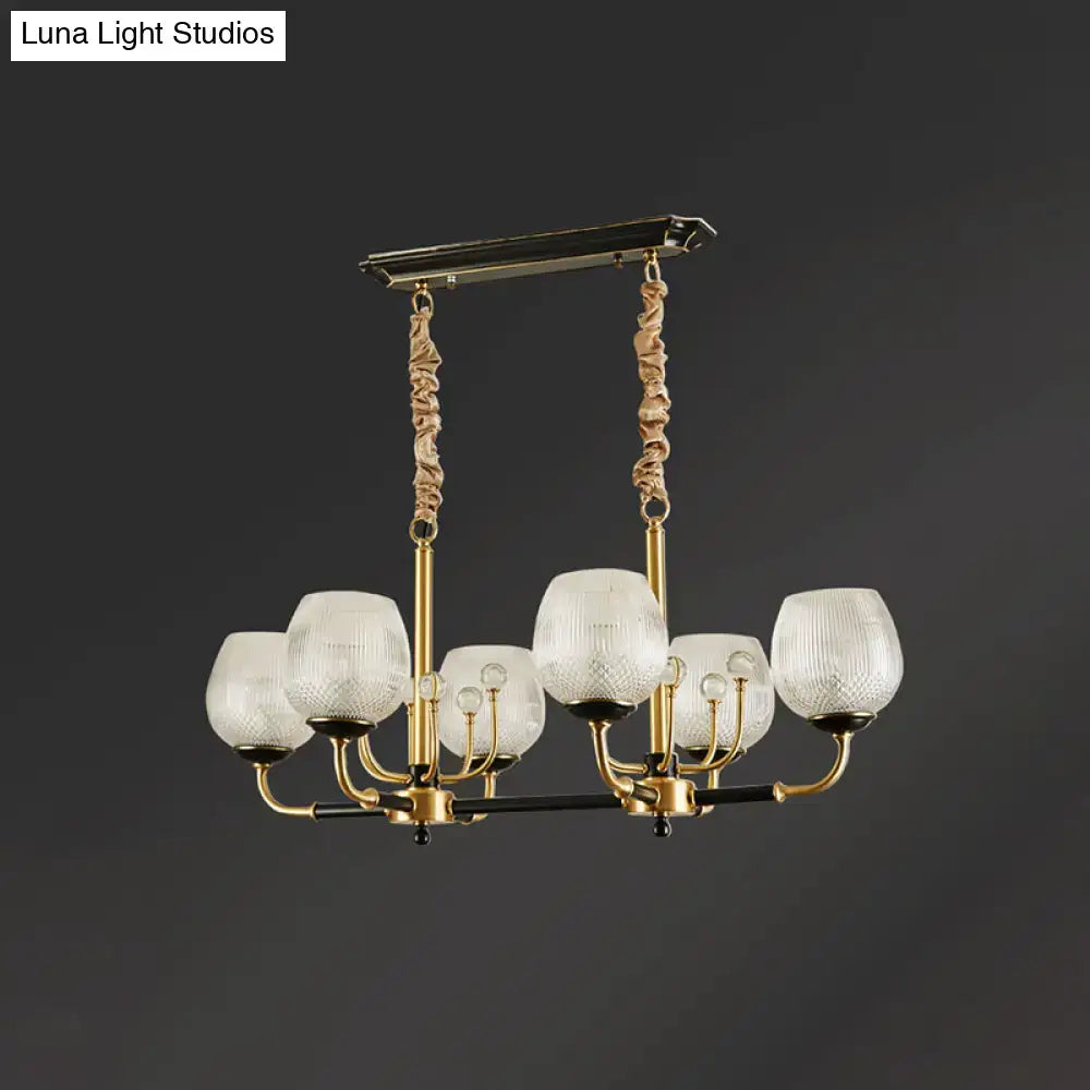 Modern gold and black ribbed glass island chandelier with six gold toned frosted glass shades and twisted rope accents