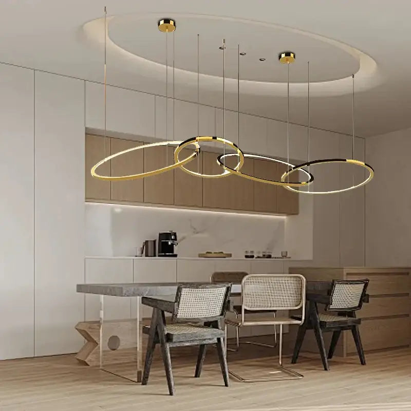 Modern gold and black stainless steel pendant lights with circular intersecting rings for dining room decorbites gold stainless