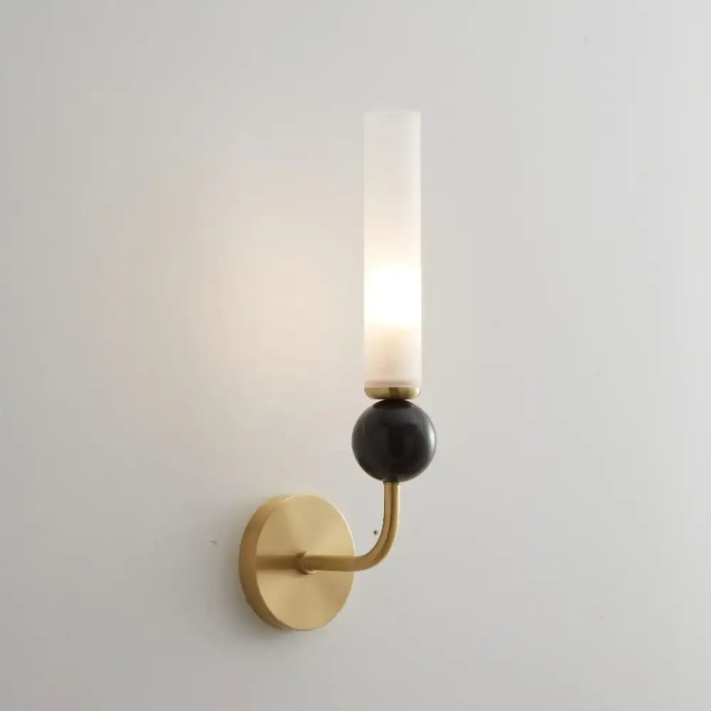 Modern gold and black wall lamp with a copper base and frosted glass shade for elegant living room decor