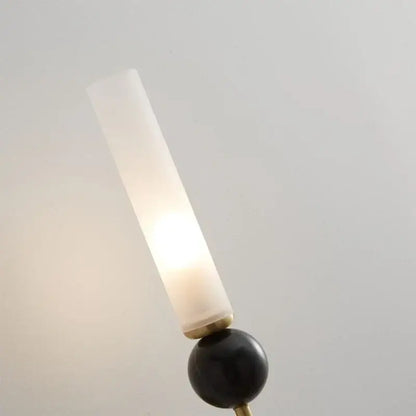 Modern gold and black wall lamp with a frosted glass shade and copper base for elegant living room decor